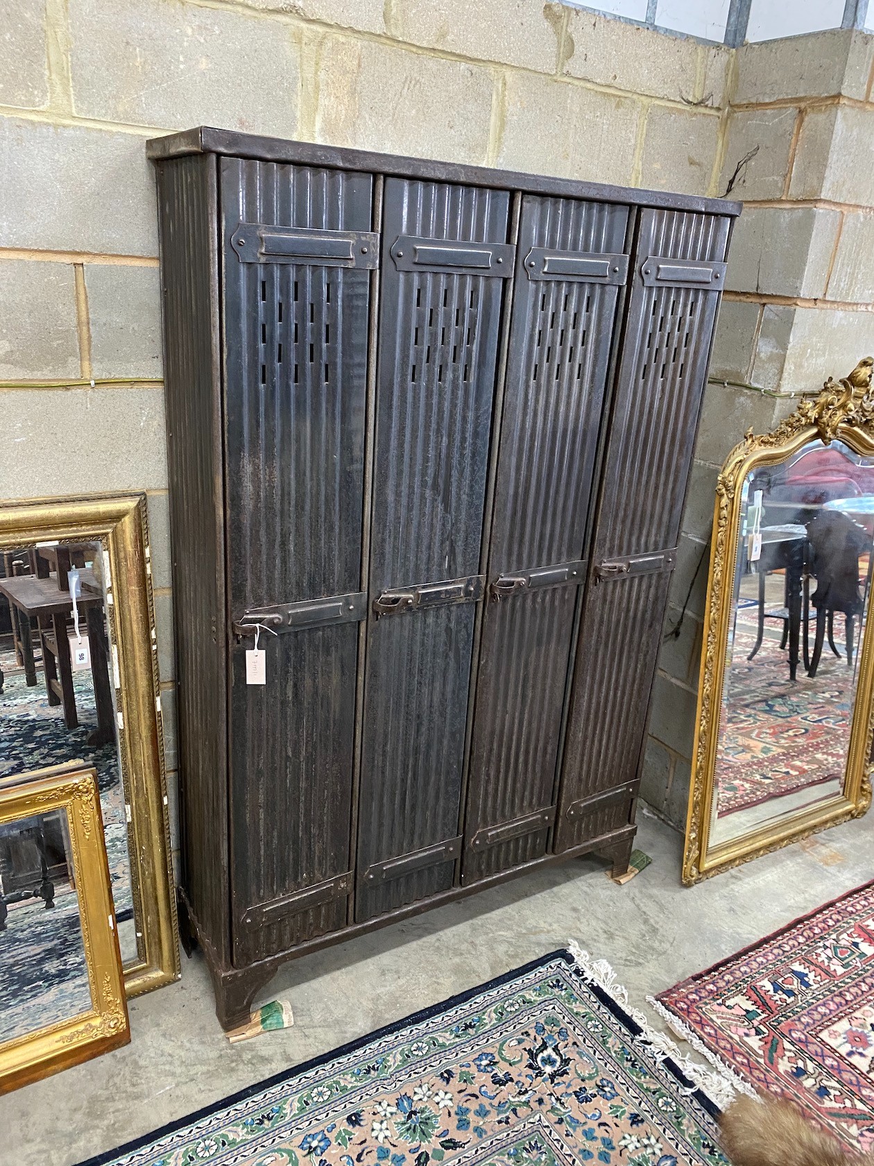 An industrial style metal four door locker, width 123cm, depth 33cm, height 184cm